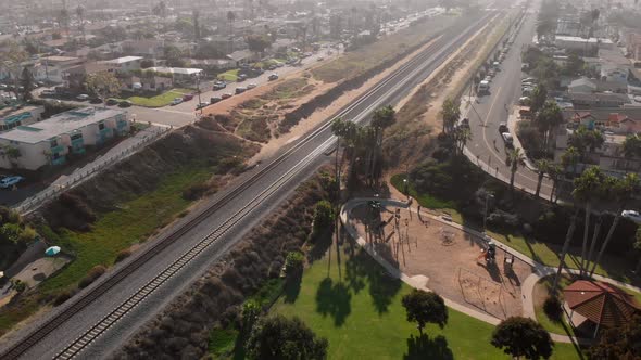 Aerial pan over a park to look down train tracks