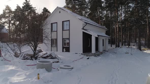 Drone shot of new white modern residential house at winter near the forest 16