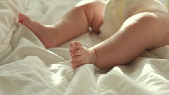 Tiny Human Feet of Caucasian Neonate Toddler is in Focus
