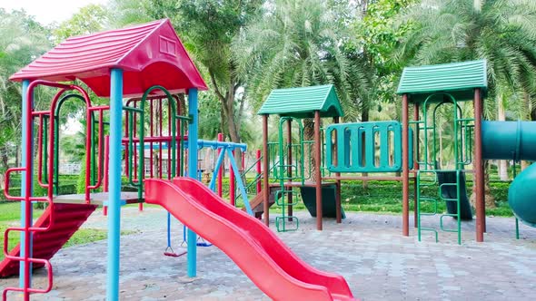 Colorful playground on yard in the park. Tunnel and Slider for children in public park.