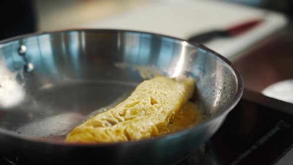 Professional restaurant kitchen, close-up: the process of cooking an omelette in a frying pan