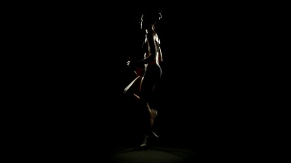 Young Athletic Woman Wearing Sporstwear is Jumping Isolated on Black