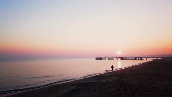 Foggy sunrise over the sea. Hazy morning. Orange sun. Drone footage. Flying slowly low over the beac