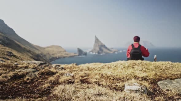 Deep Blue Sea, Drangarnir Rock and a Man Enjoying the View By the Cliff