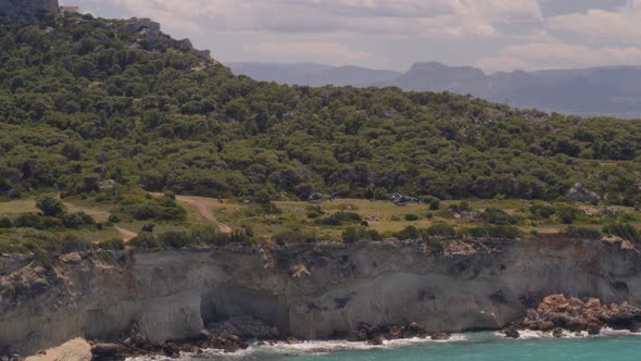 Aerial Pan of Cliffs Cascading into the Blue Ionian Sea Near Loutraki Greece