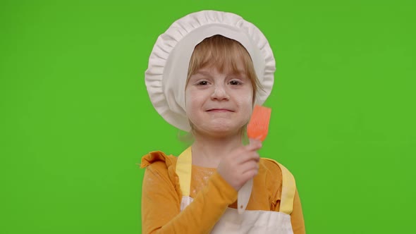 Funny Child Girl Kid Dressed Cook Chef Baker in Apron and Hat Dancing Fooling Around Making Faces