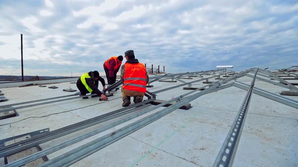 Solar panel technicians on flat roof of a big building