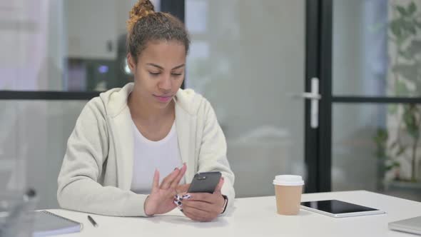 Attractive African Woman Using Smartphone in Office