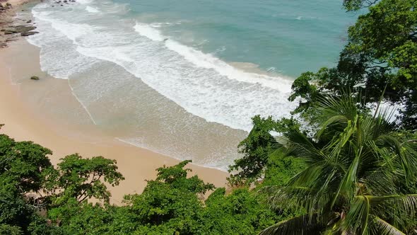 Beautiful clear waves rolling from above breaking beach.Drone shots