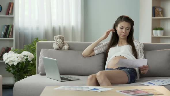 Mother-To-Be Working With Papers and Laptop at Home, Rubbing Temples, Stressful