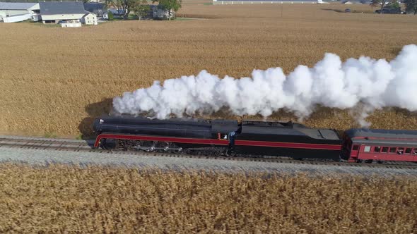 Aerial Side by Side View of a Steam Engine Blowing Steam and Smoke