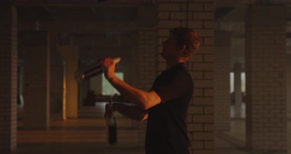 Silhouette of Professional Bartender Juggles Bottles