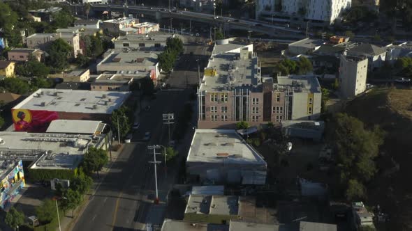 AERIAL: Flying Towards Downtown Los Angeles, California Skyline with Look at Houses and Street