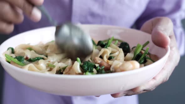 Young Man Eating Vegetable Pasta