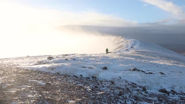 People walking on the snow in a mountain path