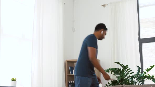 Man with Wireless Earphones Exercising at Home