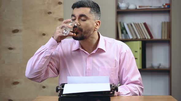 Concentrated Old-School Author Typing Book on Vintage Typewriter in His Office