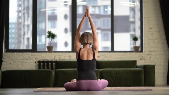 Woman Sitting in Lotus Pose and Meditating with Open Hands