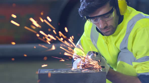 Caucasian male worker in a safty uniform wear welders leathers,Electric wheel grinding