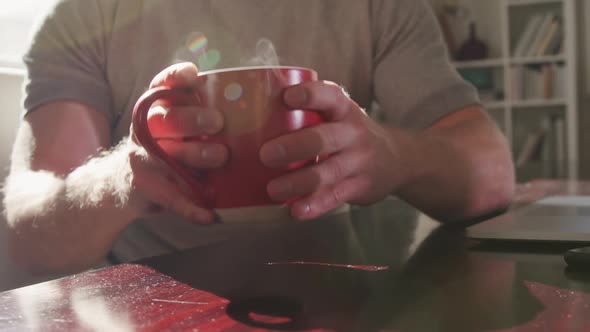 Caucasian male in social distancing drinking coffee at home