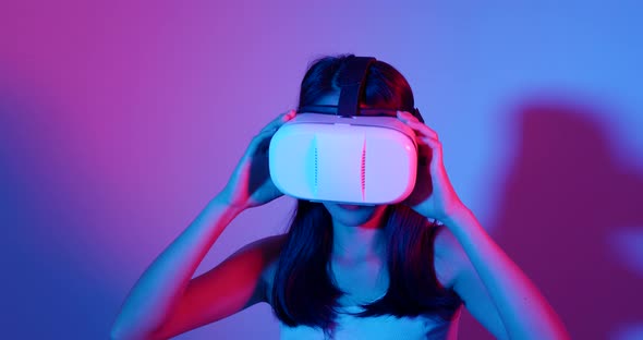 Woman looking though VR device with red and blue light 