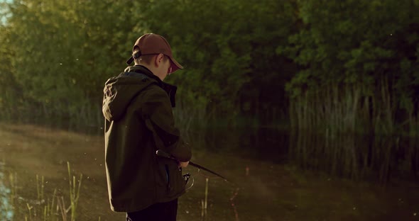 Schoolboy is Fishing Alone By Shore Beautiful Pond or River in Early Morning  Prores