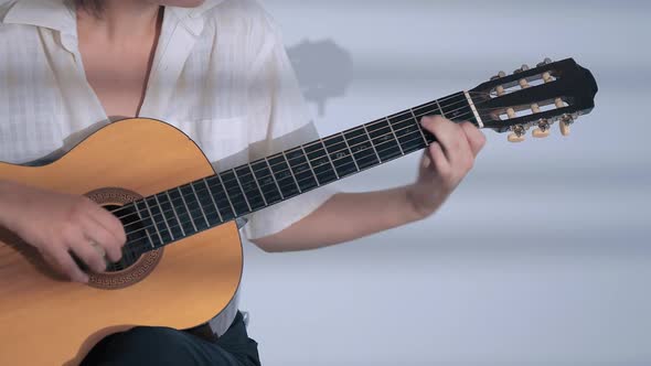 Young Woman Playing Guitar at Studio 