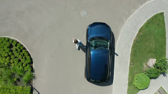 Drone Shot of Female Walking From Car To Hotel
