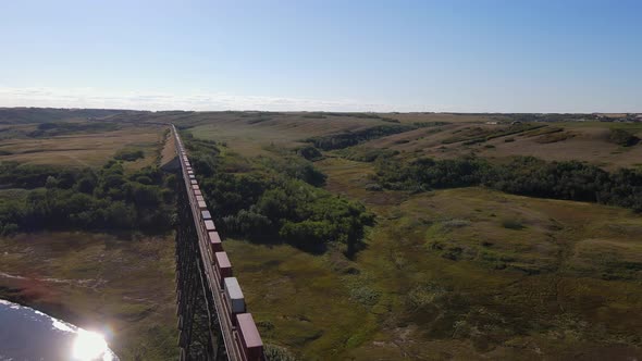 Drone footage of Battle River Trestle Bridge in Wainwright, Alberta. Train oncoming sunny day blue s