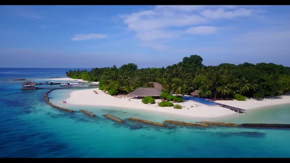 Aerial flying over sky of tranquil resort beach voyage by aqua blue sea and white sand background of