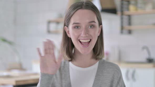 Portrait of Young Woman Smiling and Waving at Camera