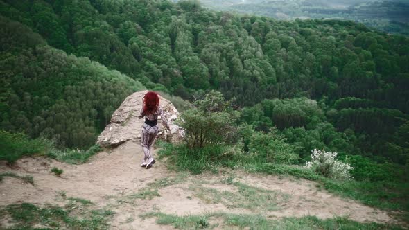 Athletic Girl Runs Along Top Mountain