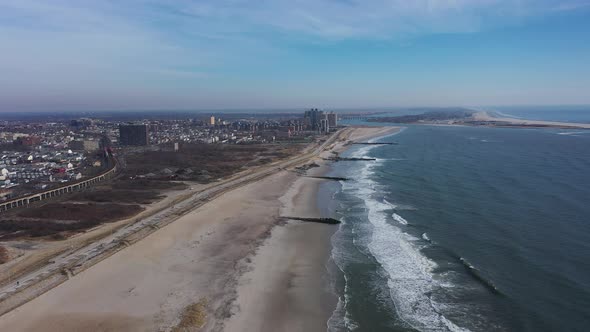 A high angle view of an empty beach on a beautiful day with a few clouds. The camera dolly in over t