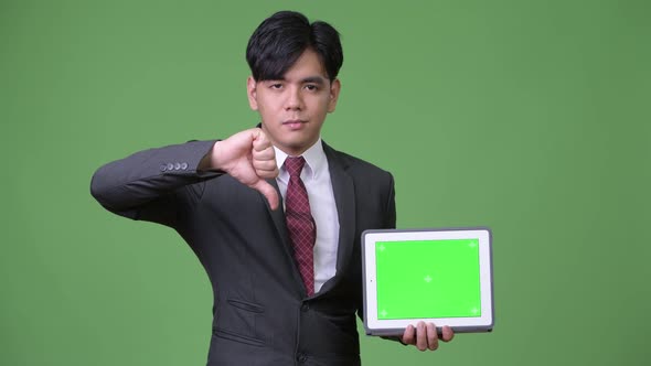 Young Handsome Asian Businessman Using Digital Tablet