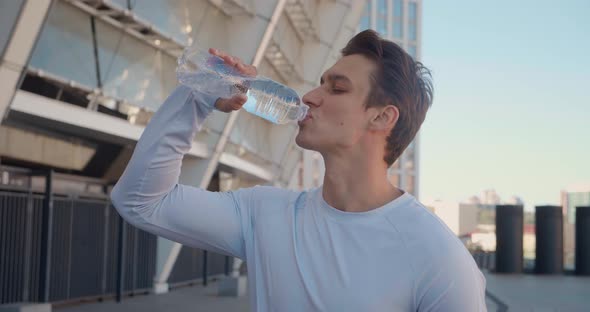 Handsome Young Male Athlete Drinking Clean Water After Workout Training Outdoors on Stadium