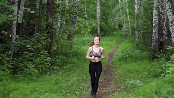 Beautiful Young Caucasian Woman in Fitness Wear Working Out in a Park