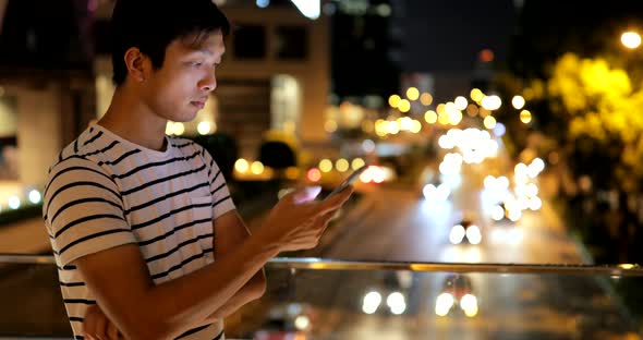 Young man using smart phone in city