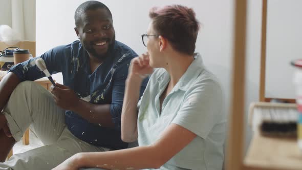 Positive Multiethnic Couple Chatting during Home Renovation