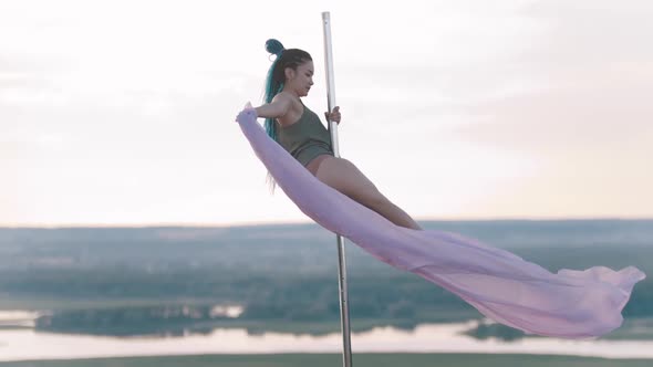 Pole Dance Outdoors - Woman with Long Blue Braids Spinning on the Pole with Pink Veil