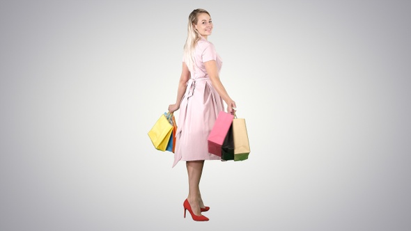 Happy young woman making a turn with shopping bags in her