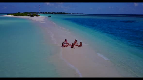 Girls posing on marine lagoon beach break by clear ocean with white sand background of the Maldives 