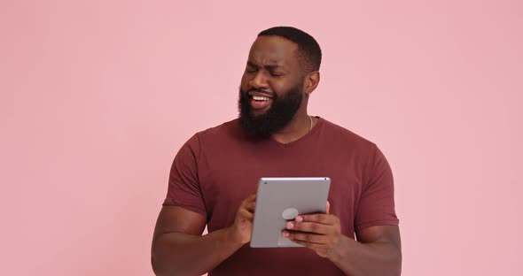 Young African American Man Use Tablet Eureka Success Isolated on Pink Background