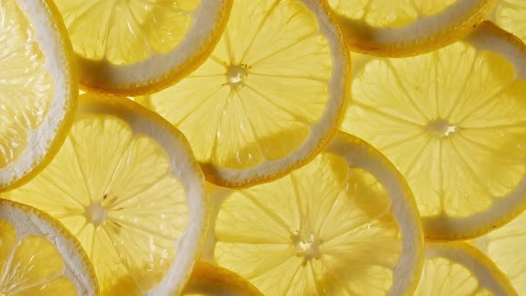 Slow Motion of Fresh Lemons Slices on Yellow Background