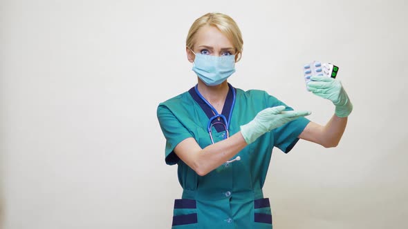 Medical Doctor Nurse Woman Wearing Protective Mask and Rubber or Latex Gloves - Holding Pills