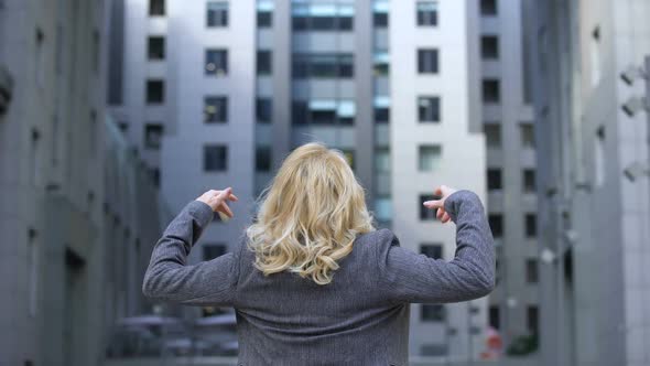 Carefree Blond Woman in Formal Suit Raising Hands Up Back View, Female Wellness