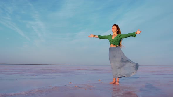 Girl Stands on Lake with Arms Outstretched