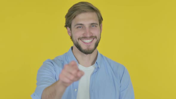 Young Man Pointing at the Camera on Yellow Background
