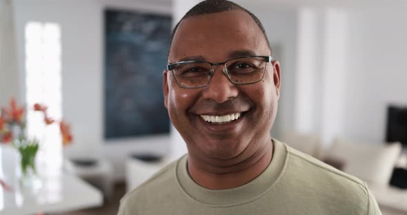 Senior african man looking and smiling in camera at home