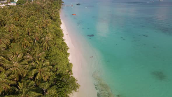 Panorama of the Maldivian island with a coastline on which a pier and a mooring loca are located in