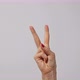 Woman raising two fingers up and showing peace or victory symbol or letter V - VideoHive Item for Sale